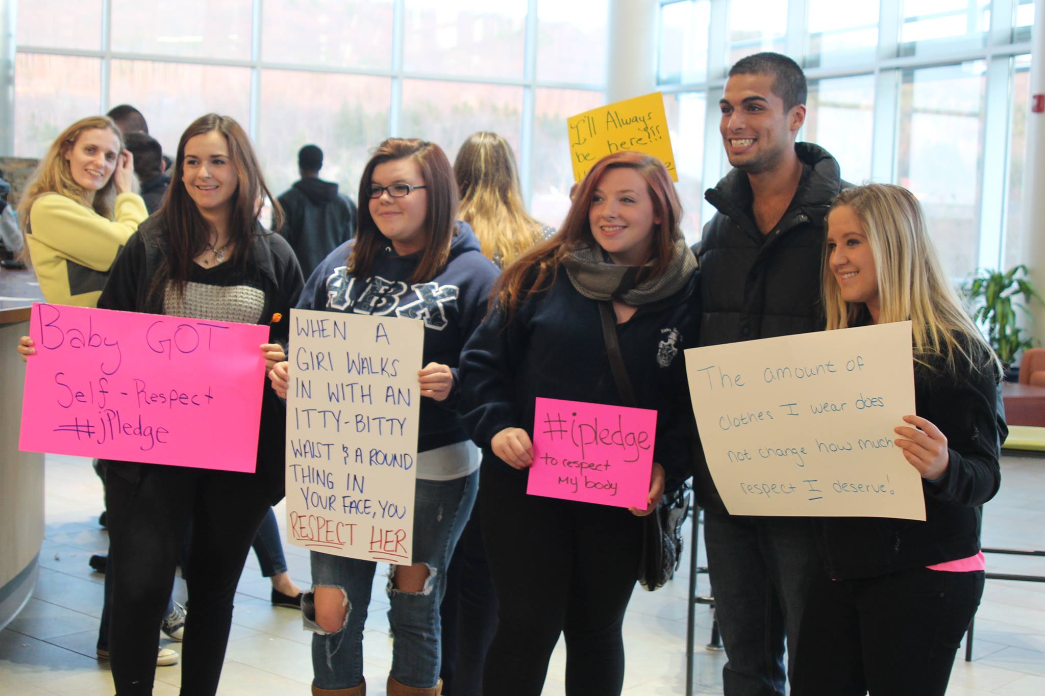 students at Take Back The Night event holding posters