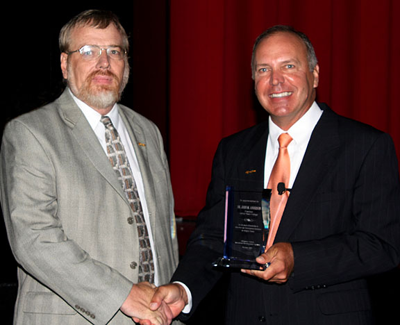 Clark (left) accepts the award from Anderson