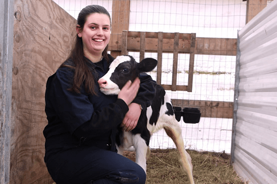 Caroline hugging a calf on the farm
