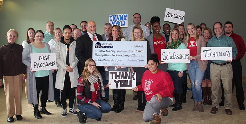 Students, faculty, and staff presenting a check and holding up Thank You signs