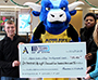 mascot holding a big check surrounded by students