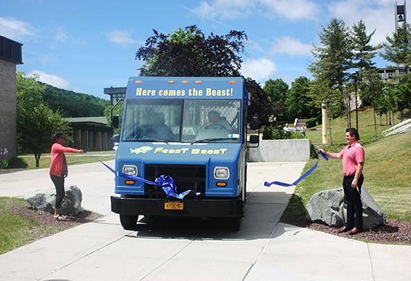President Dr. Skip Sullivan drives the new “Feast Beast” food truck through a ribbon during a ceremony