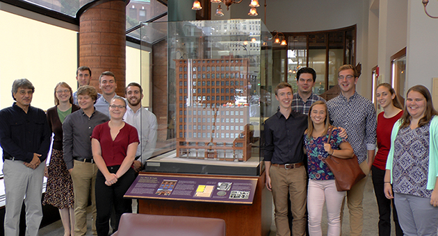 Associate Professor David Carli, left, and the students who constructed the model, standing next to the model