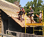 students working on the roof of a house