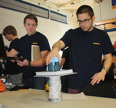 Alex Surdyk, an electrical engineering technology major from Hamburg, right, judges one of the entries in the design challenge that was part of Friday’s National Engineers Week event.