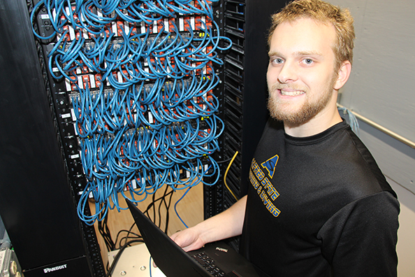 student standing in front of a bunch of blue wires