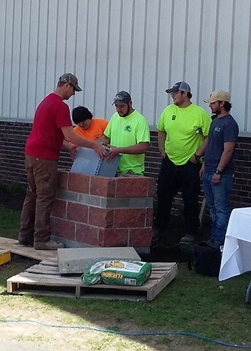 Wellsville students lower the time capsule into its spot 