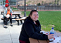 two students sitting outside each at a picnic table