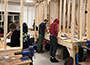 students in a carpentry lab, pieces of lumber
