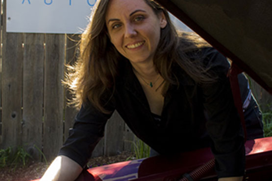 Kate Jonasse standing next to a car, underneath the hood