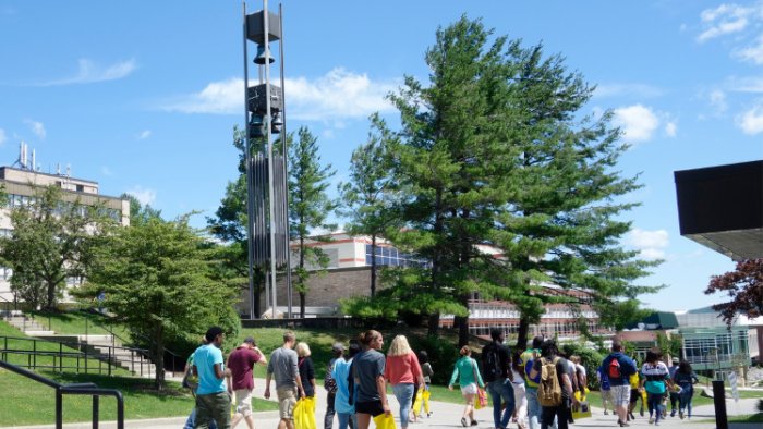 Students walk down the spine of campus by the Bell Tower.