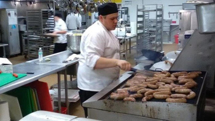 A culinary arts students works on the grill
