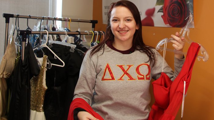 Delta Chi Omega sister Jenna Plouse shows off one of the dresses that will be available at Project Prom Dress. The event will be held April 8 in the Pioneer Center.