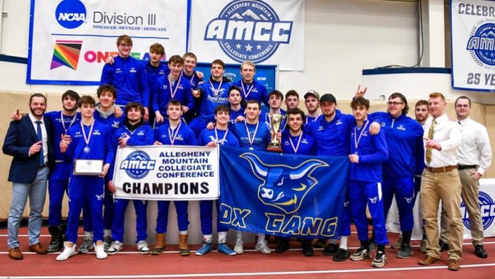The Alfred State wrestling team poses with the championship trophy and banner after winning the AMCC Championship