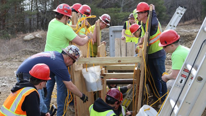 students work on a trench collapse simulation