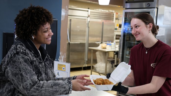 A student worker serves another student food