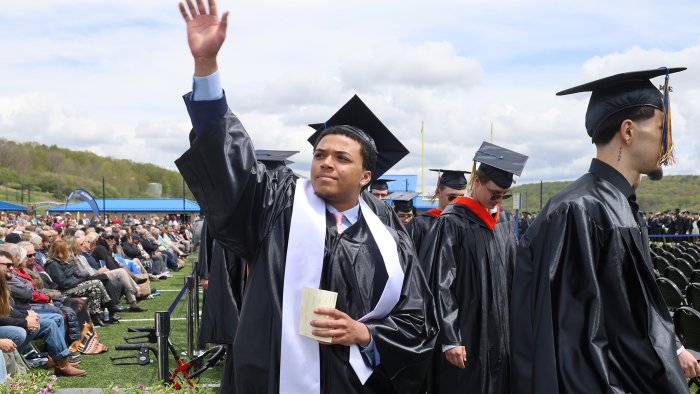 An Alfred State student waves to family during Commencement