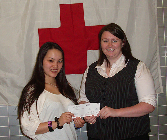 Graduate Rina Taguchi presents a check to Erin Dickerson, American Red Cross
