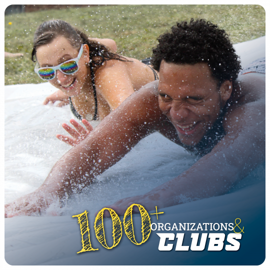 Link to Student clubs and organizations. 100+ organizations and clubs. Image of two students enjoying the slip and slide with water droplets.