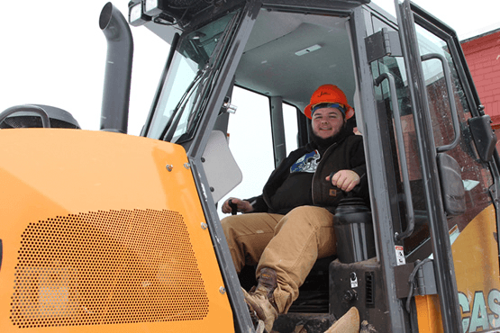 Austin driving a piece of heavy equipment