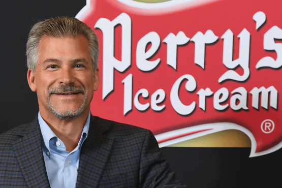 Brian Perry standing in front of Perry's Ice Cream logo