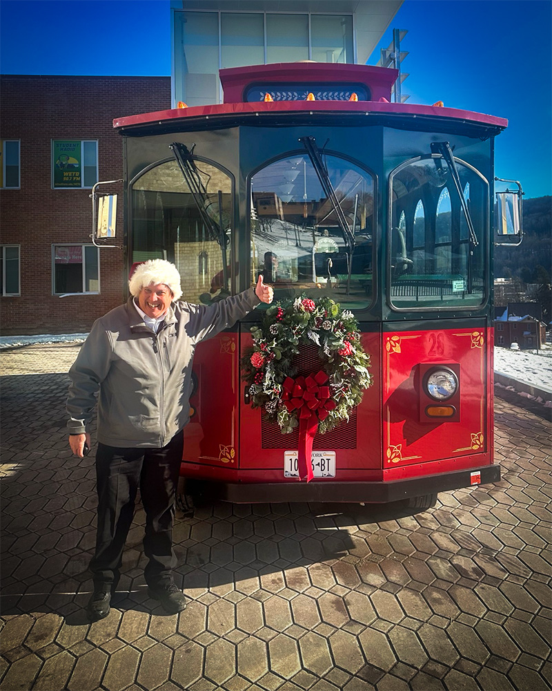 Photo of Stuart (Stu) Blitz in front of the new trolley.