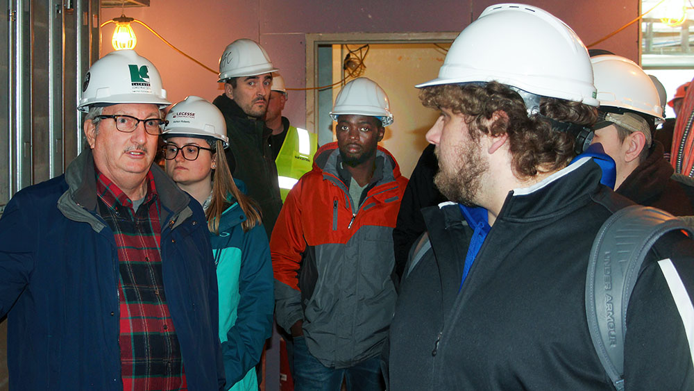 Photo of Tim Piotrowski on a construction site with ASC students