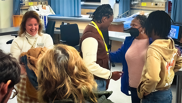 Photo of Jody Blankenship shares a laugh with parents and students during a nursing lab tour.