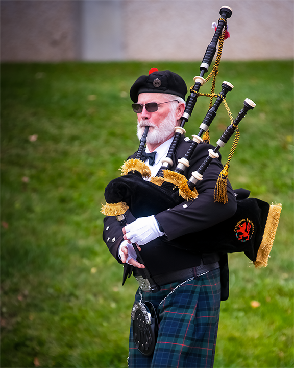 GreyWolf the Piper leads the Pioneer Walk from the Orvis Activities Center to the Student Leadership Center