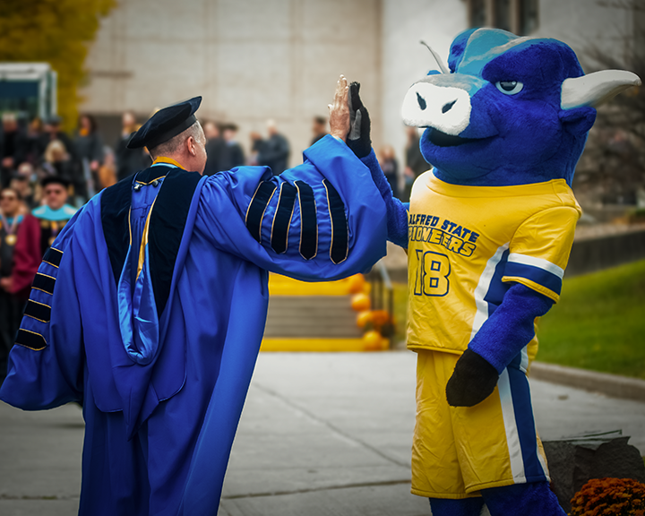 Dr. Steven Mauro high fives Big Blue during the Pioneer Walk