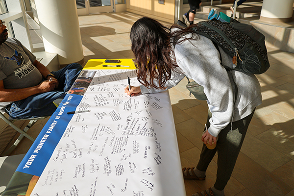 Photo of student signing Derek's banner.