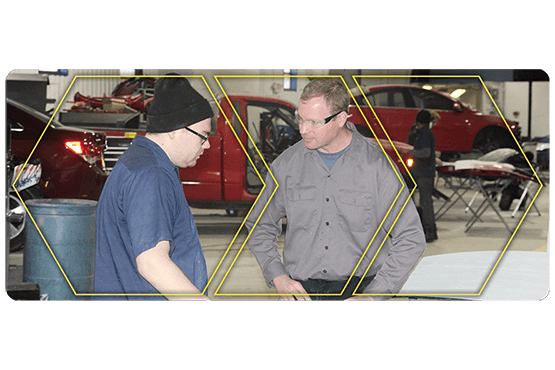 Christopher Tremper with a student in the automotive lab