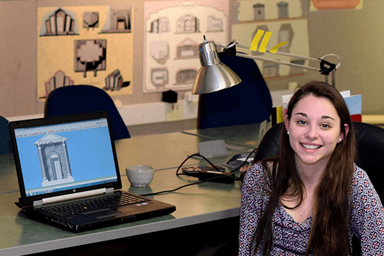 Sarah Travers sitting at a table with a laptop