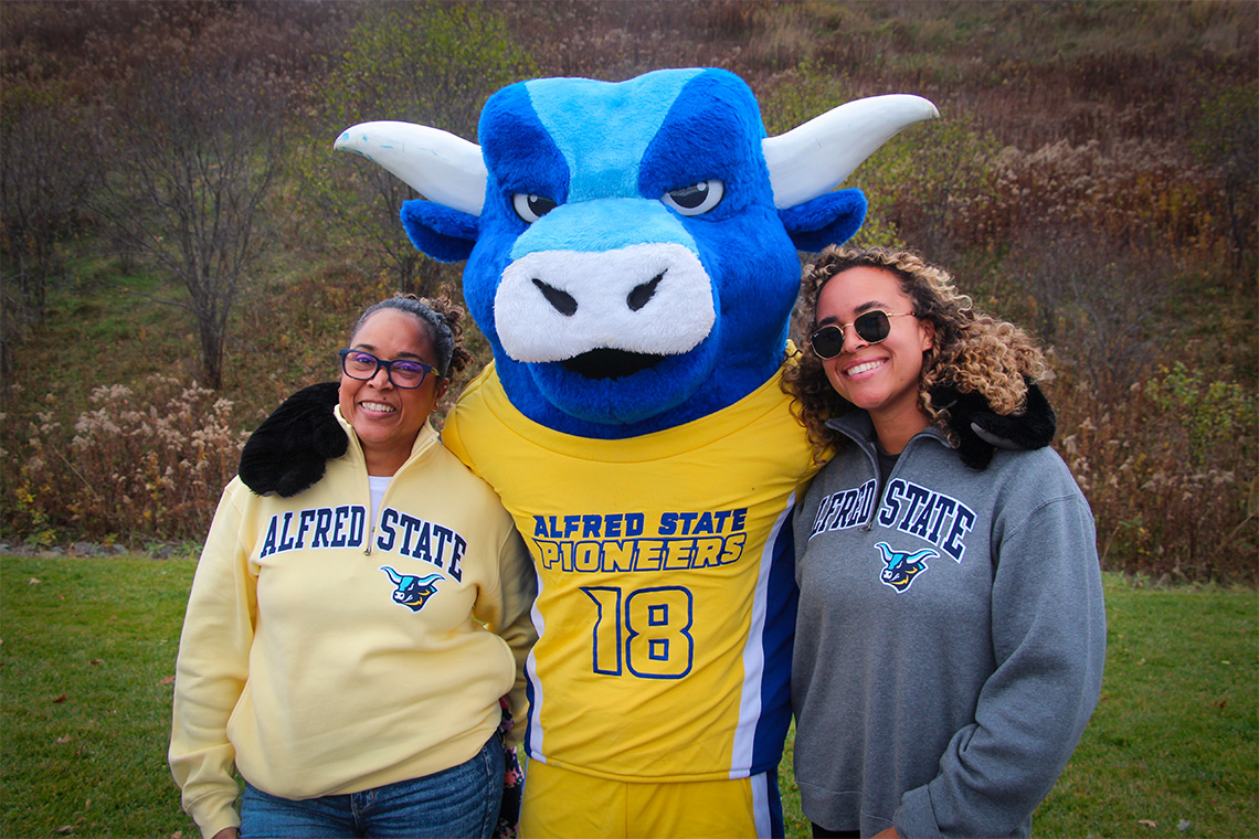 ASC mascot Big Blue posing with mother and daughter