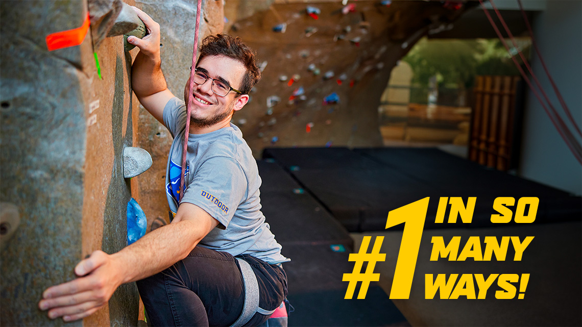 ASC Student climbing a rock-climbing wall