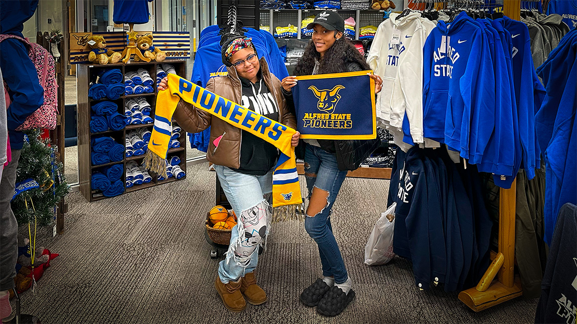 ASC students attending posing with apparel at the Campus Store