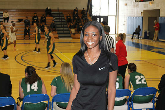 Tatyana in gymnasium with basketball game in background