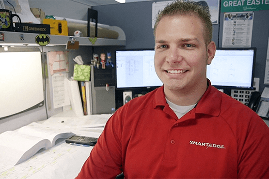 Taylor Battaglia sitting in his cubicle at work