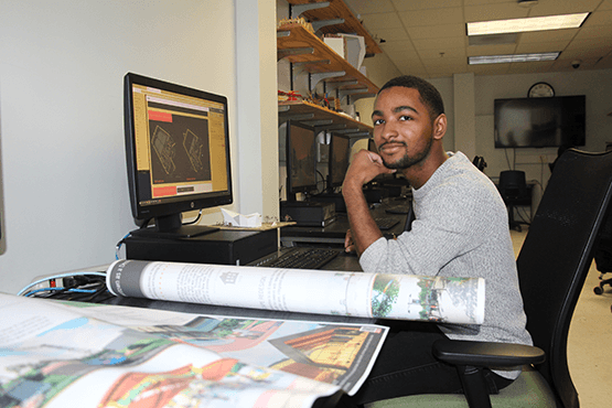 Caleb Boyce-Wright sitting at a desk with computer and papers