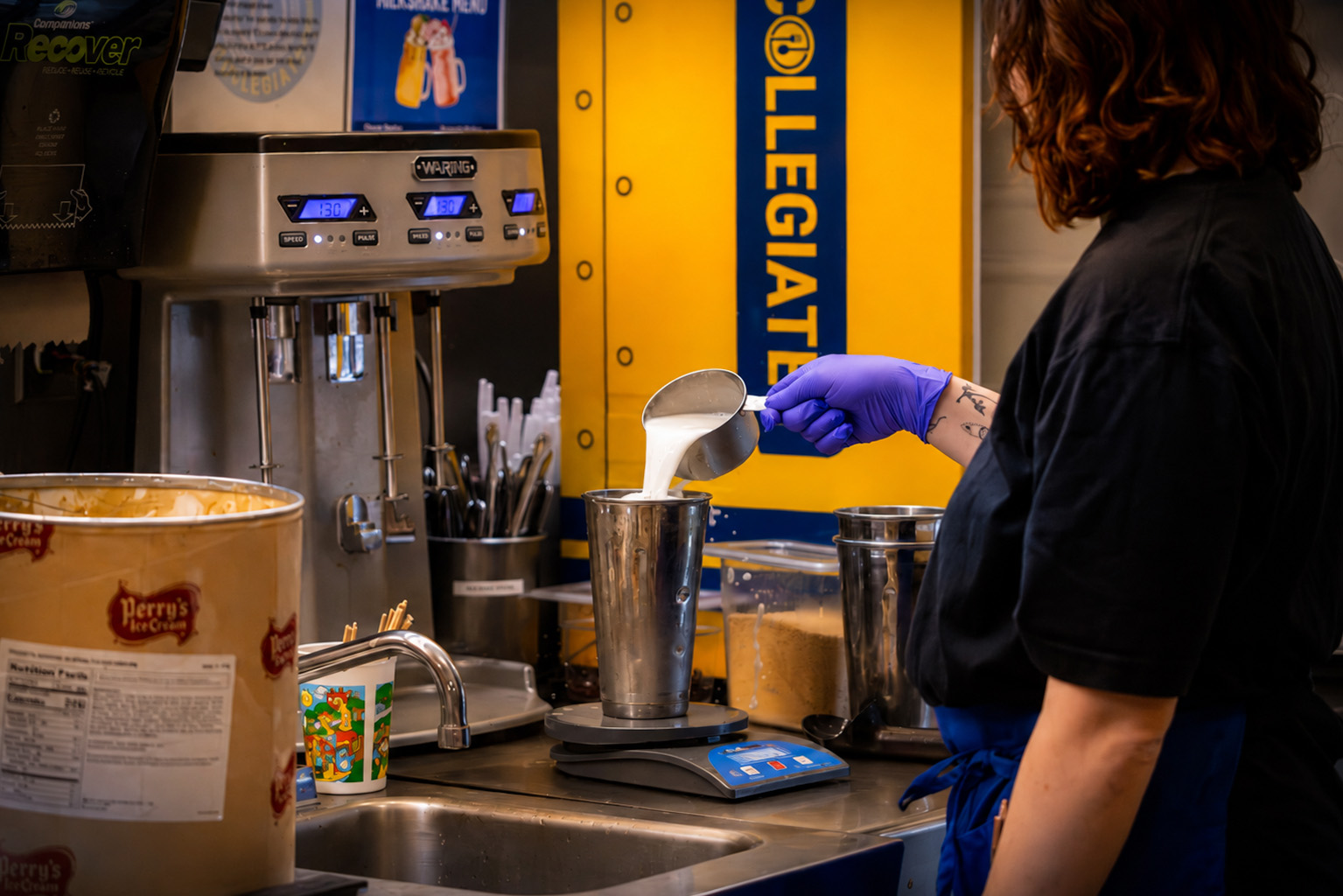 A food service worker preparing a delicious milkshake at the Collegiate.