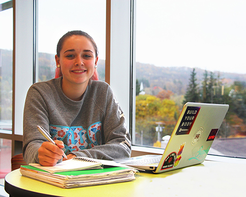 female student sitting in front of laptop at table