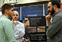 student speaking with two men at career fair