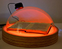 an open book under a piece of glass with a red light shining on it