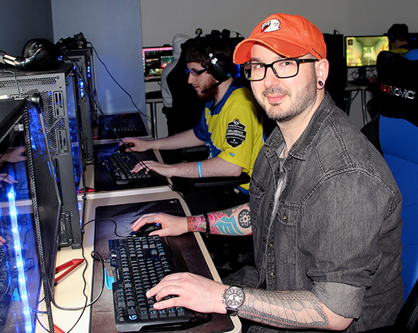 Eric Doty sitting at a computer wearing an orange hat