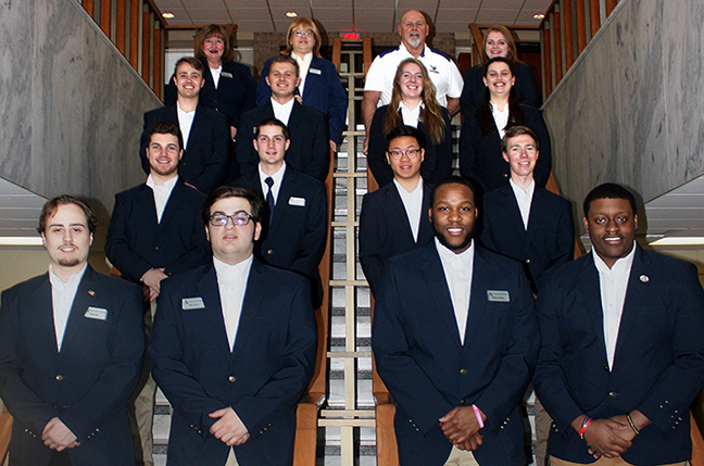 several students standing on staircase wearing blue coats