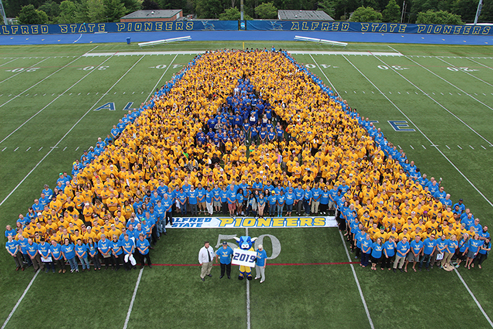 students and faculty and staff create the letter A