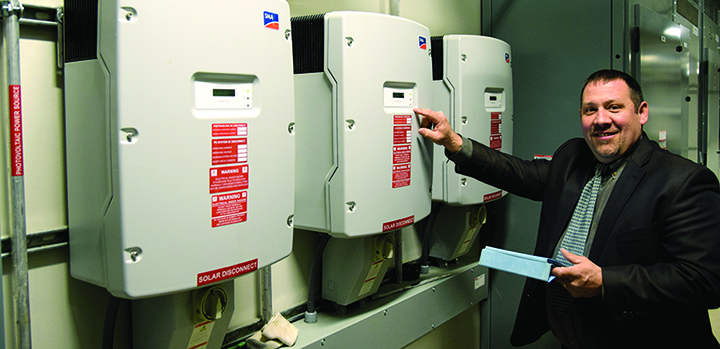 Glenn Brubaker, director of Facilities Operations at Alfred State, takes readings from the 18 kW photovoltaic arrays