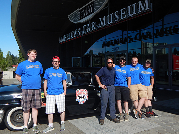 students standing in front of a car