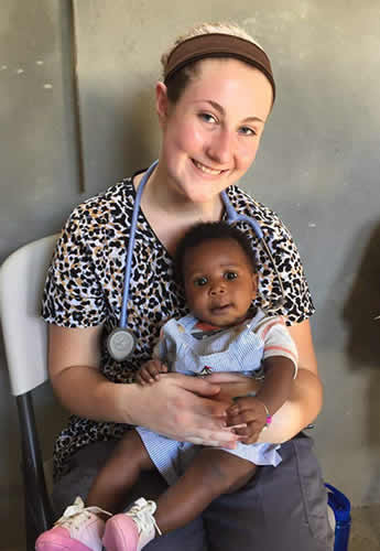 Taylor Voigt holds a child at one of the mobile medical clinics set up in Onaville, Haiti
