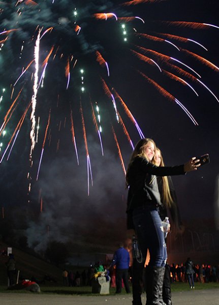 students taking a selfie in front of a firework